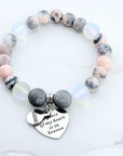 Beaded bracelet with a heart-shaped charm on a white background