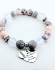 Beaded bracelet with heart-shaped charm and engraved text on a white background