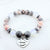 Marble beaded bracelet with a heart-shaped charm on a white background