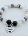 Bracelet with beads and a heart-shaped charm on a white background
