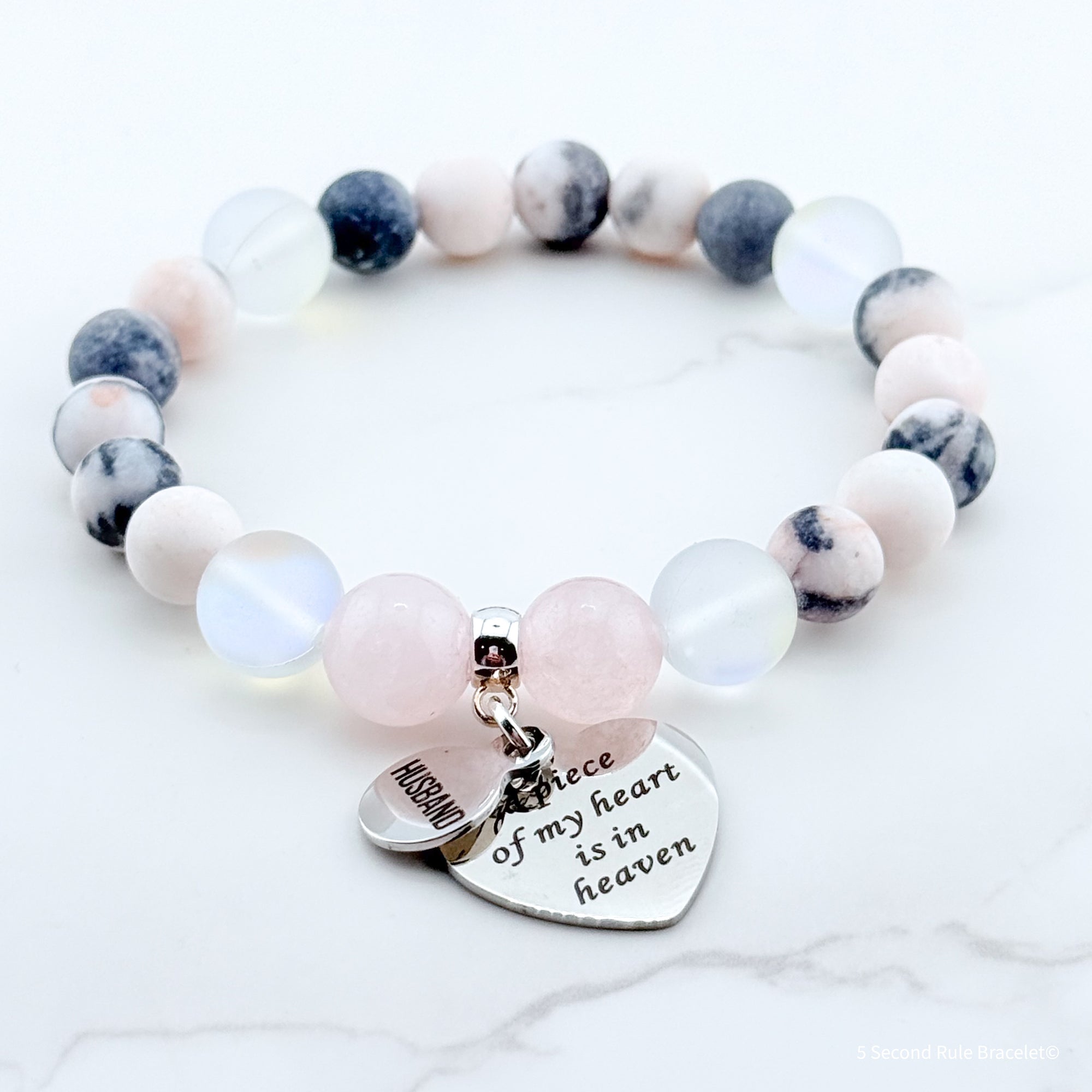 Beaded bracelet with heart-shaped charm on a white background