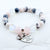 Beaded bracelet with heart-shaped charm on a white background