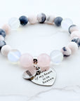Beaded bracelet with heart-shaped charm on a white background