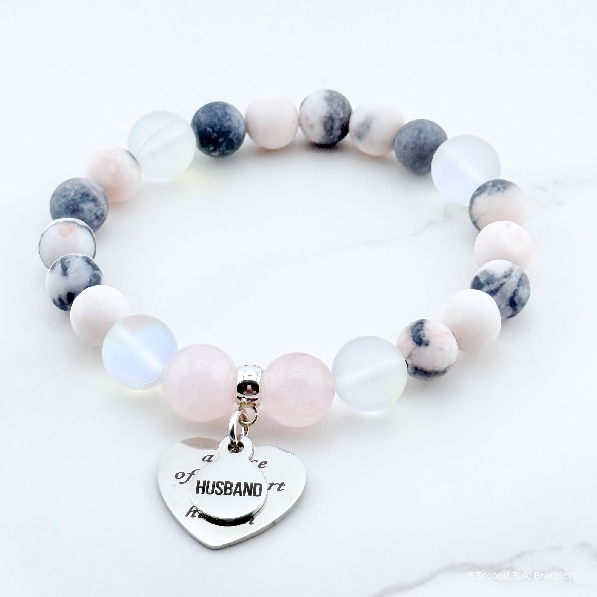 Beaded bracelet with a heart-shaped charm on a white background