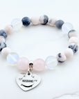Beaded bracelet with a heart-shaped charm on a white background
