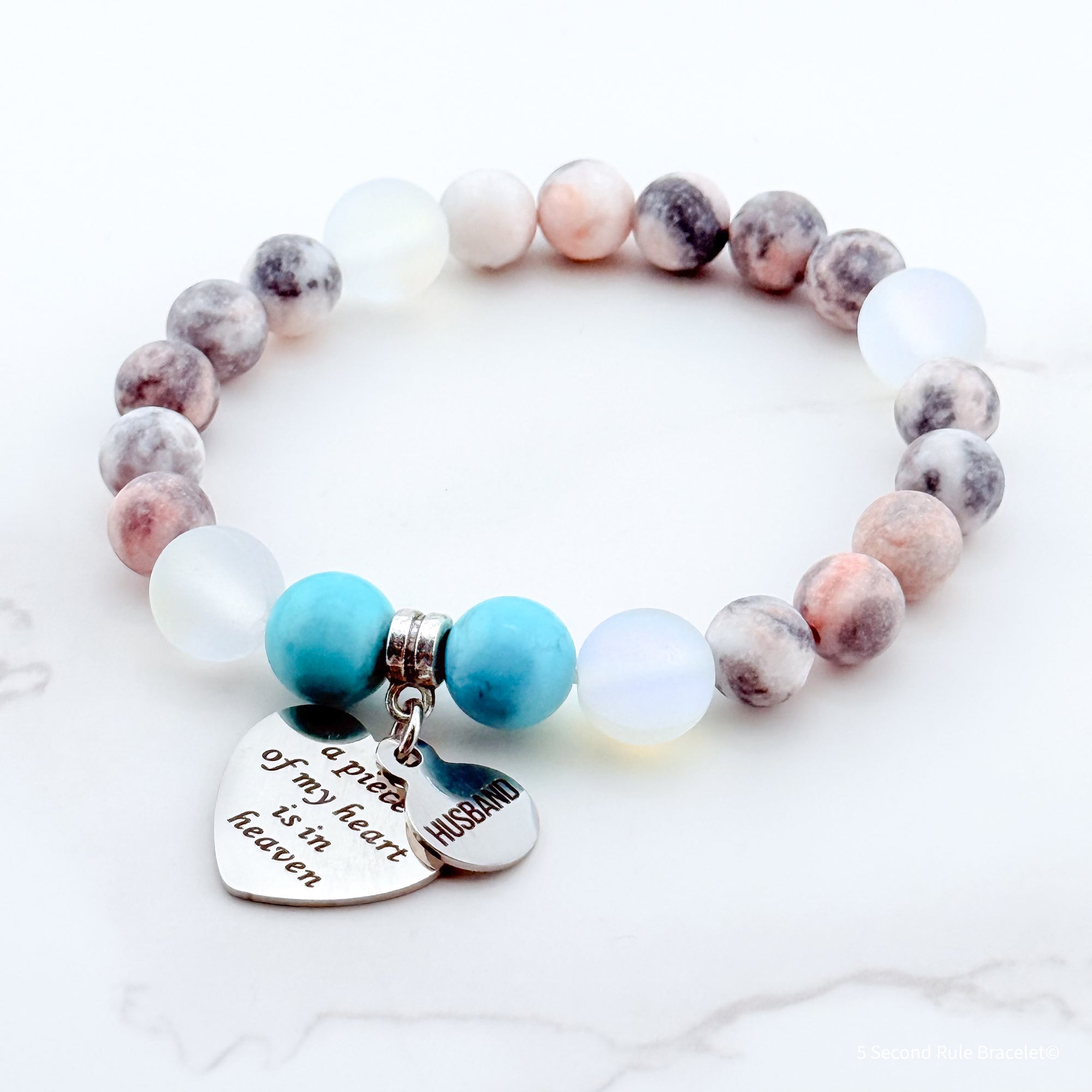 Beaded bracelet with heart-shaped charms on a white background