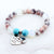 Beaded bracelet with heart-shaped charms on a white background
