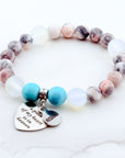 Beaded bracelet with heart-shaped charms on a white background