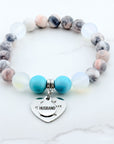 Bracelet with multicolored beads and a heart-shaped charm on a white background