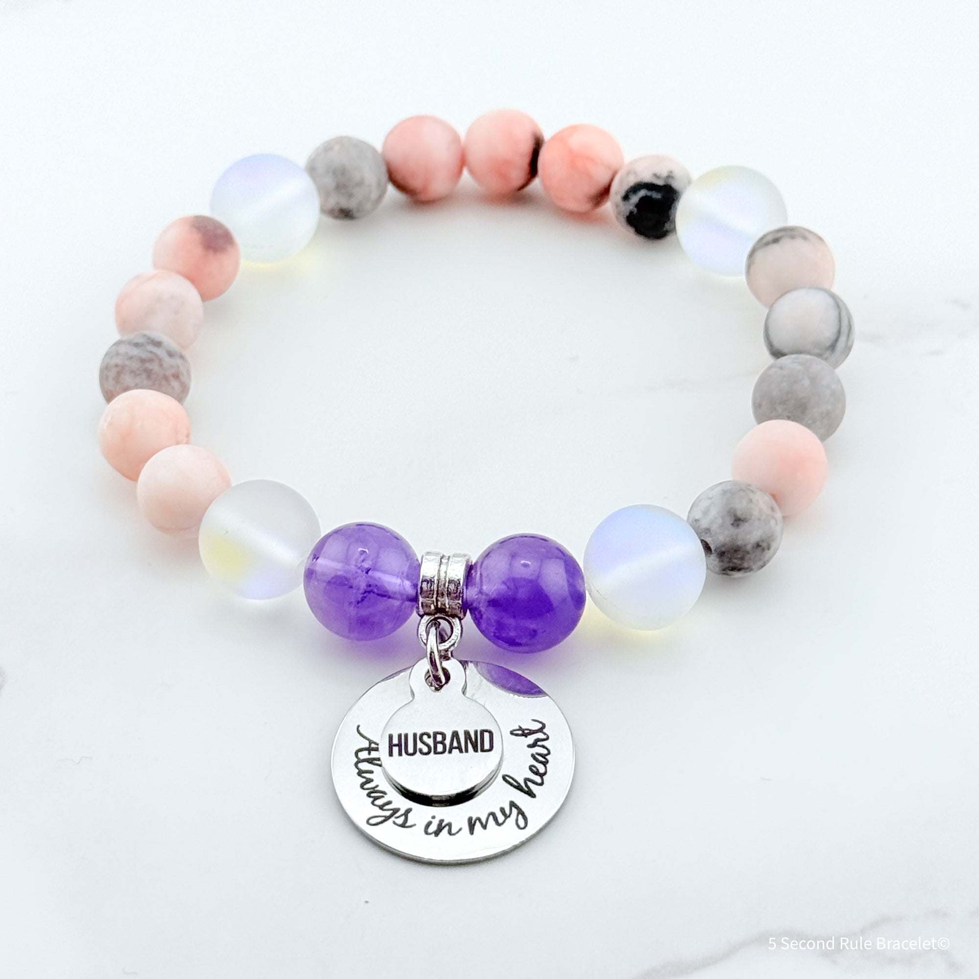 Beaded bracelet with a 'Husband always in my heart' charm on a white background