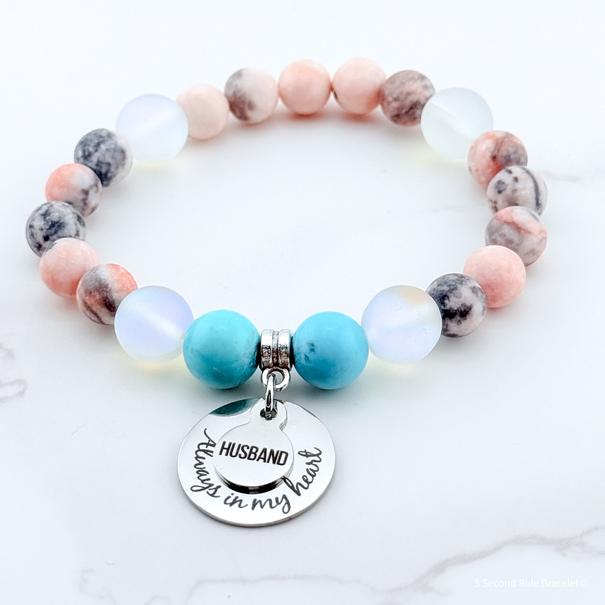 Beaded bracelet with a 'Husband always in my heart' charm on a white background