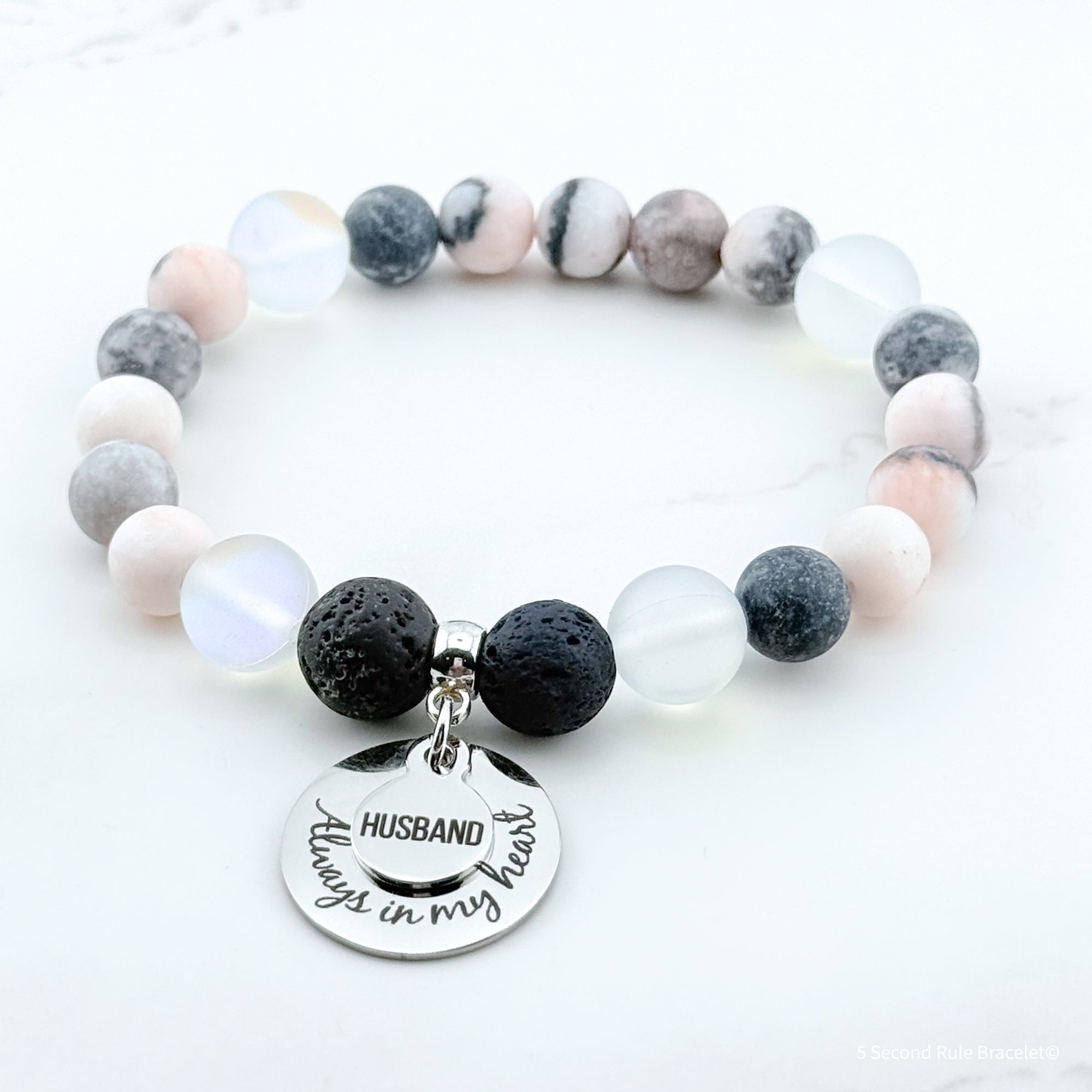 Bracelet with beads and a charm that reads 'Husband always in my heart' on a white background