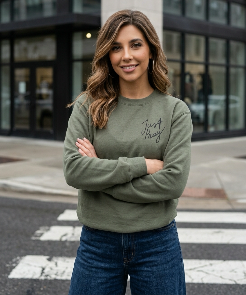 Woman wearing a green sweatshirt with text, standing on a city street.