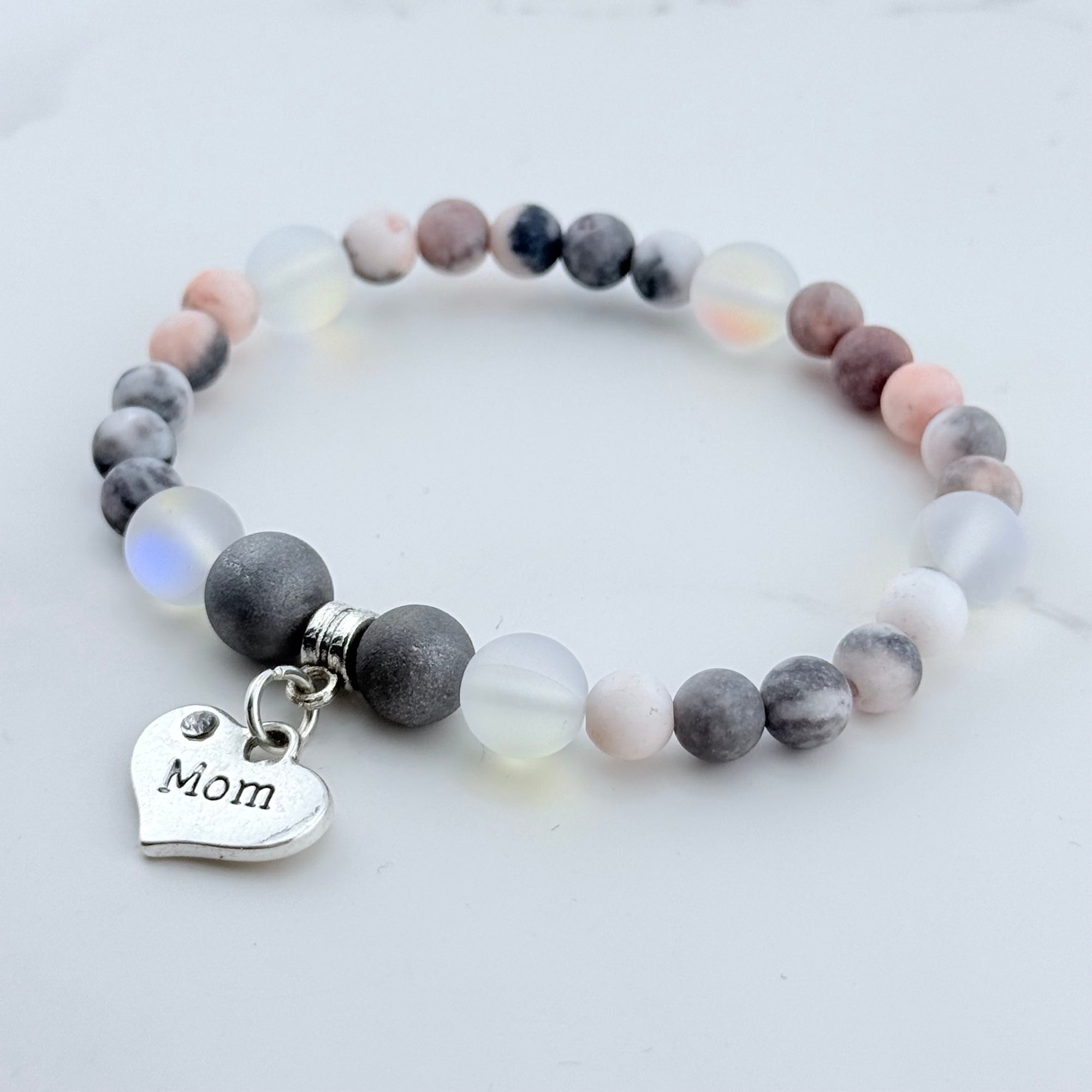Beaded bracelet with 'Mom' charm on a light background