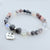 Beaded bracelet with 'Mom' charm on a light background