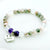 Beaded bracelet with 'Mom' charm on a light background