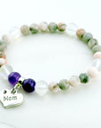Beaded bracelet with 'Mom' charm on a light background