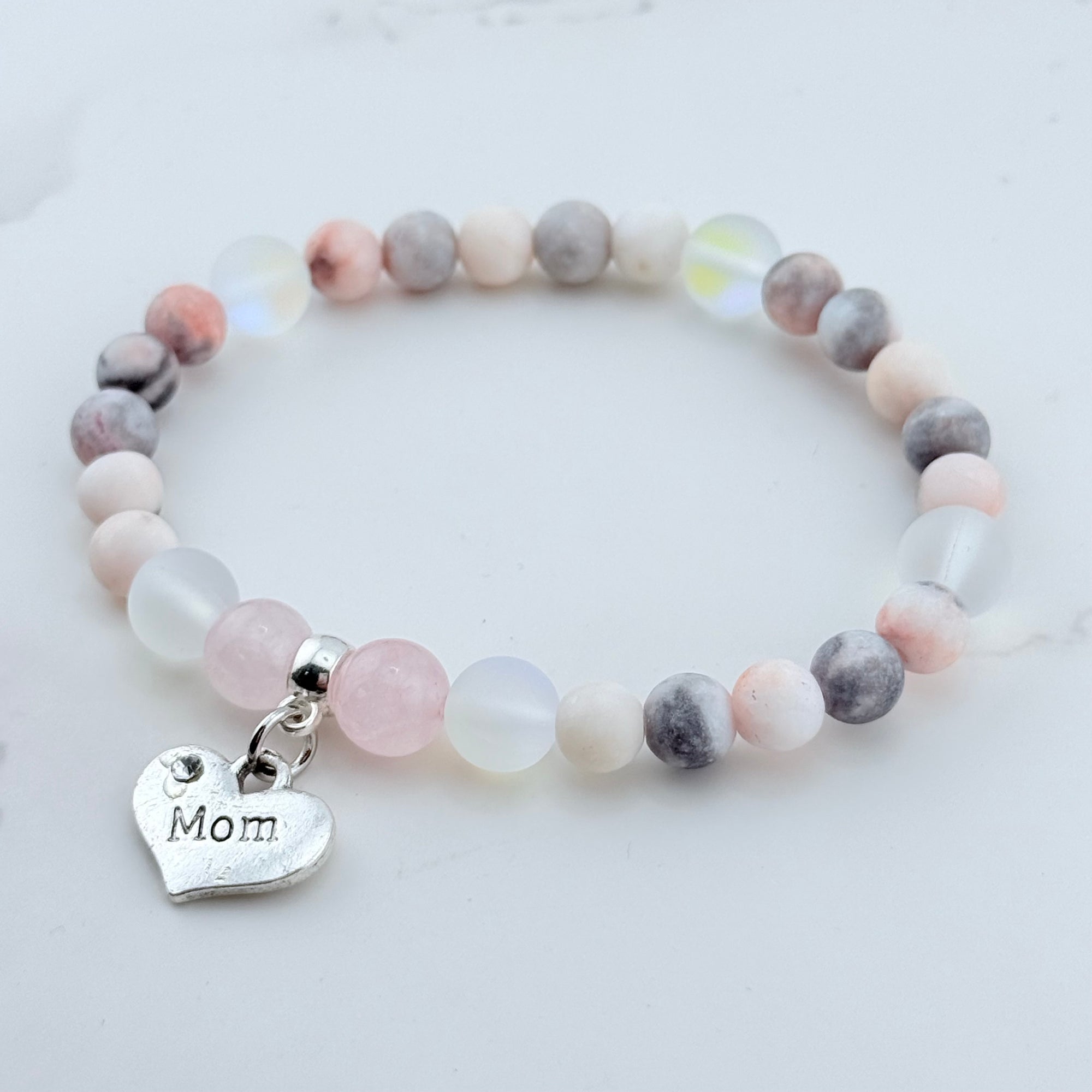 Beaded bracelet with a 'Mom' charm on a light background