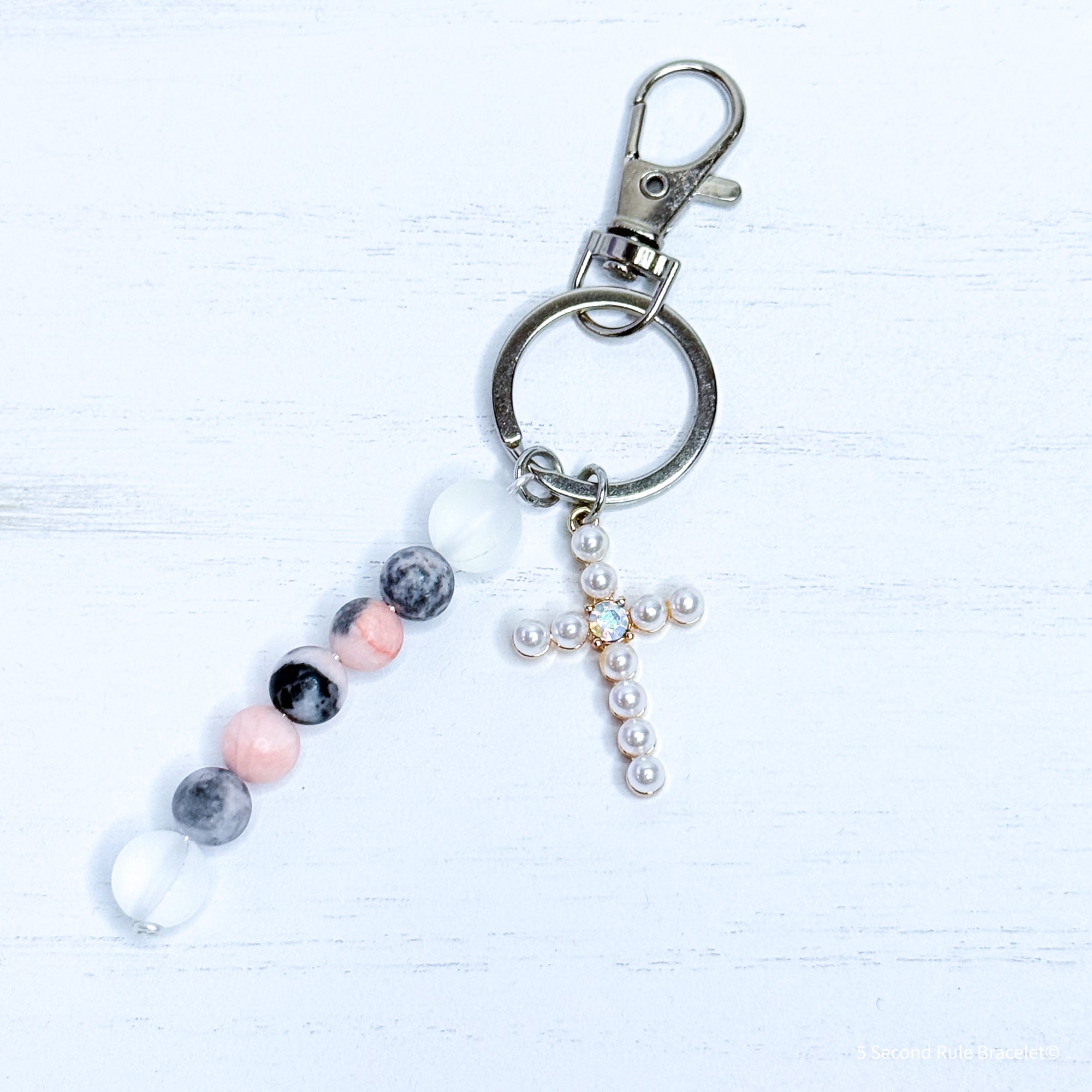 Keychain with beads and a cross charm on a white background