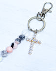 Keychain with beads and a cross charm on a white background