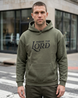 Man wearing a green hoodie with 'Praise the Lord' text standing on a city street.
