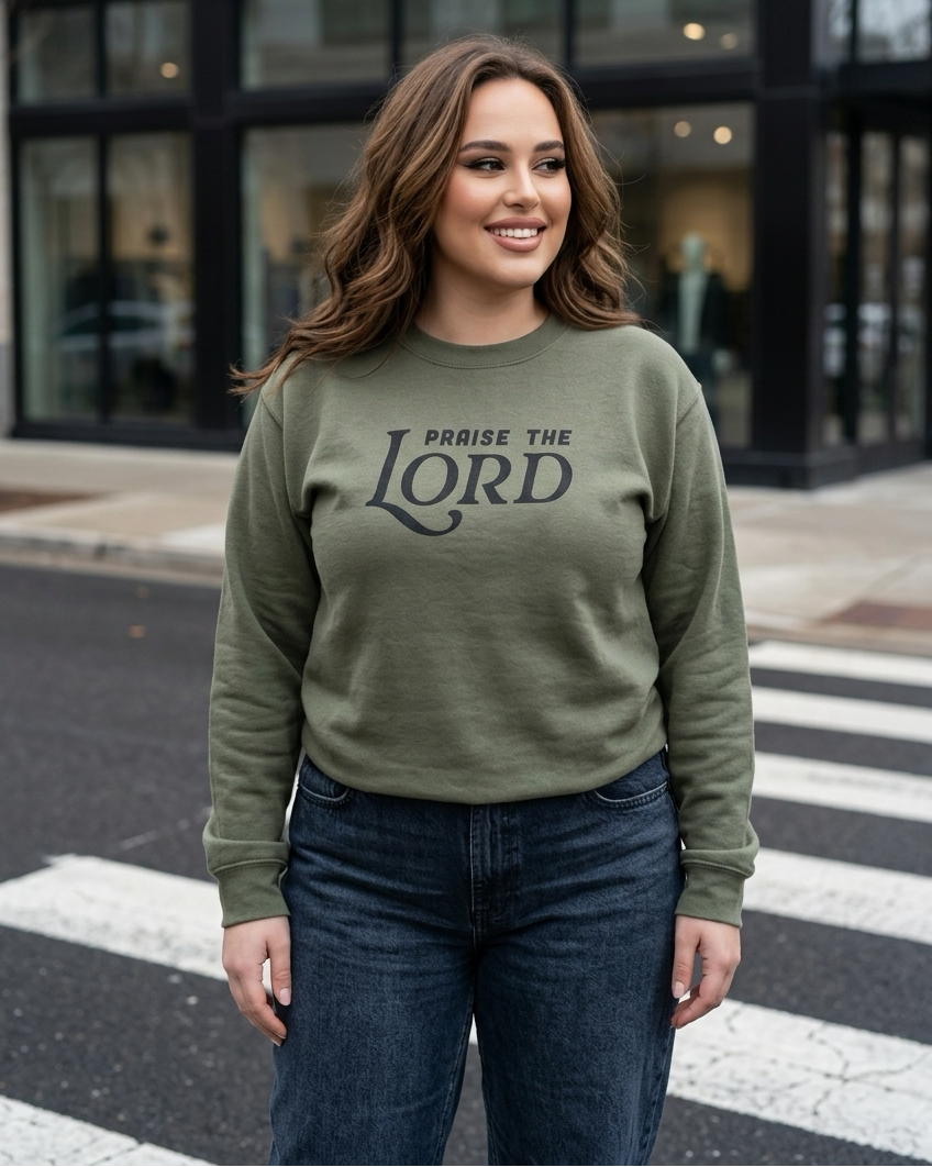 Woman wearing a green sweatshirt with 'Praise the Lord' text on a city street.
