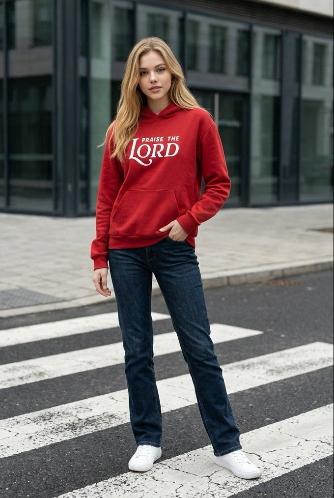 Person wearing a red hoodie with text standing on a crosswalk.