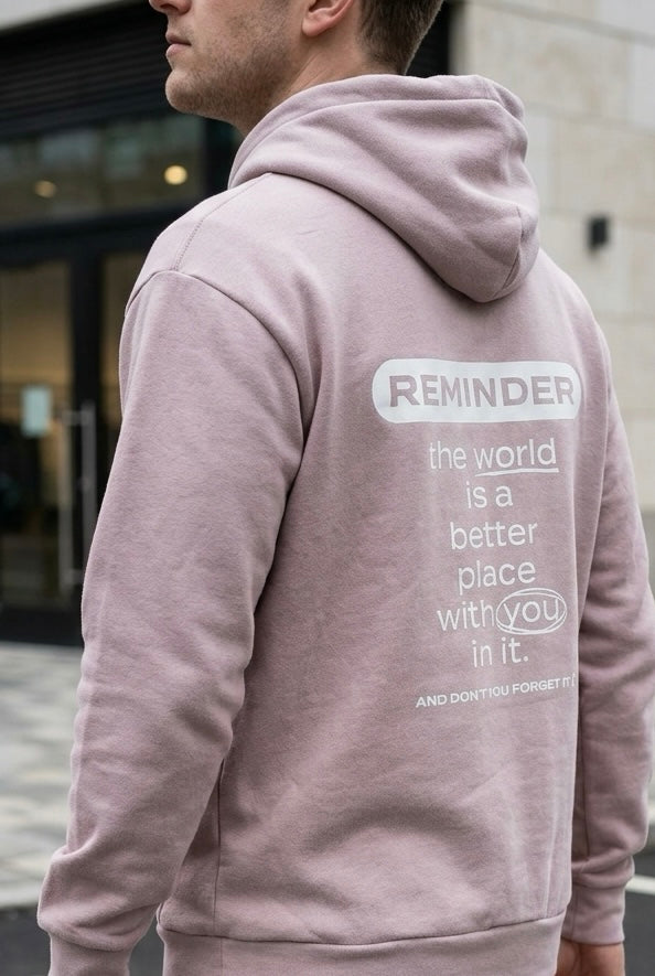 Person wearing a pink hoodie with a motivational message on the back.