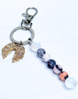 Keychain with beaded charm and decorative elements on a white background