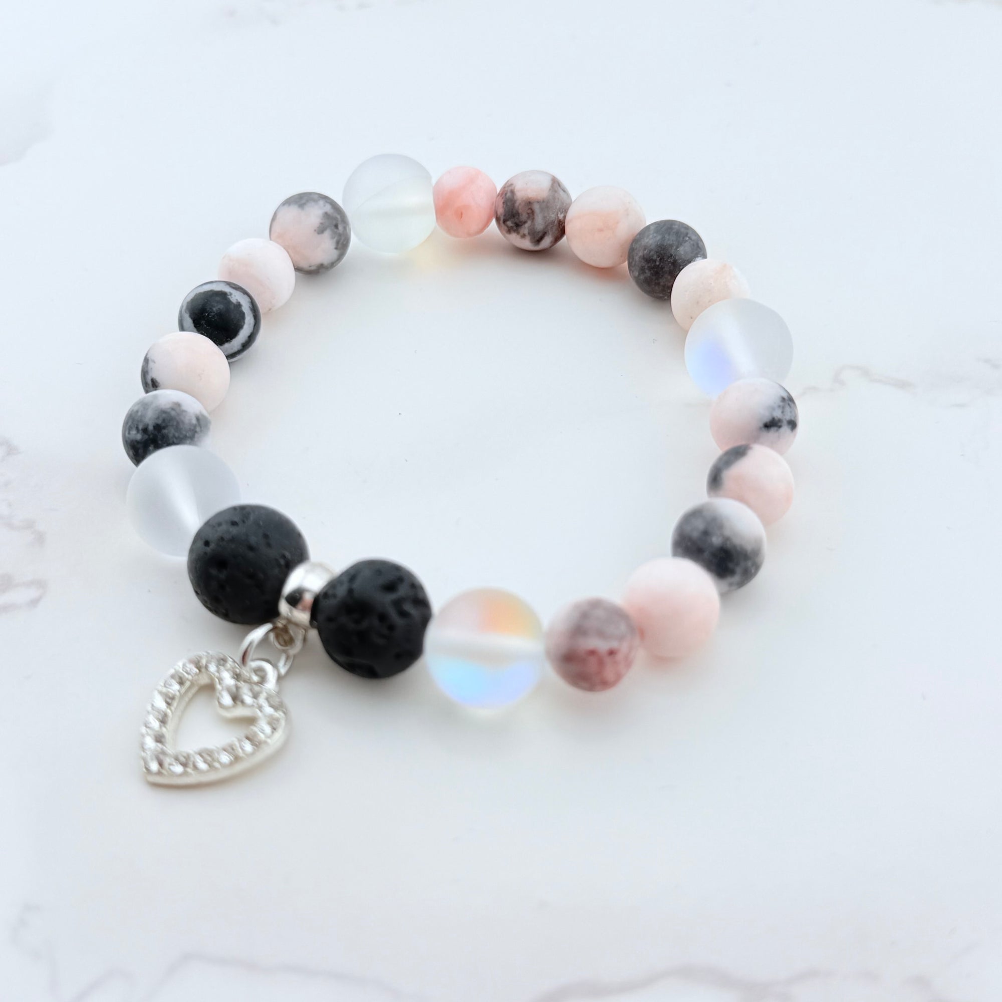 Bracelet with multicolored beads and a heart charm on a light background