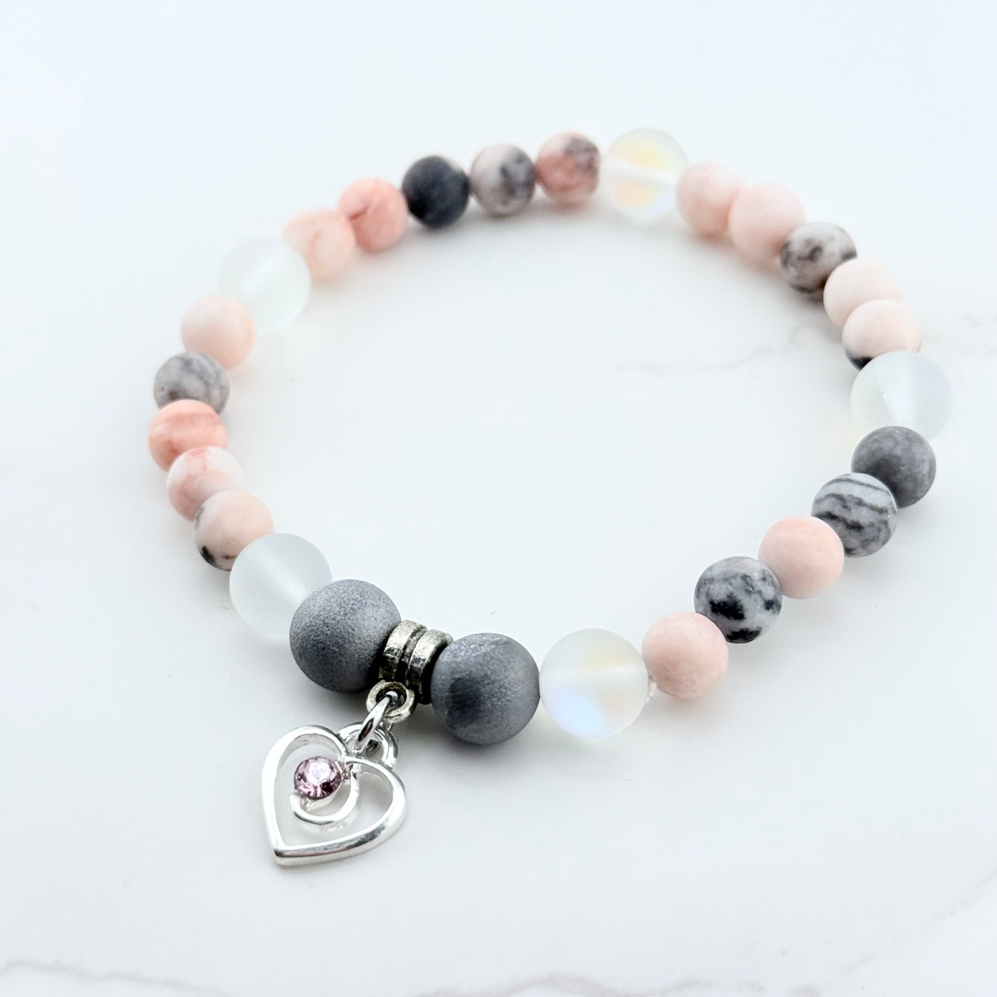 Beaded bracelet with a heart-shaped charm on a white background