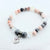 Beaded bracelet with a heart-shaped charm on a white background