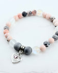 Beaded bracelet with a heart-shaped charm on a white background