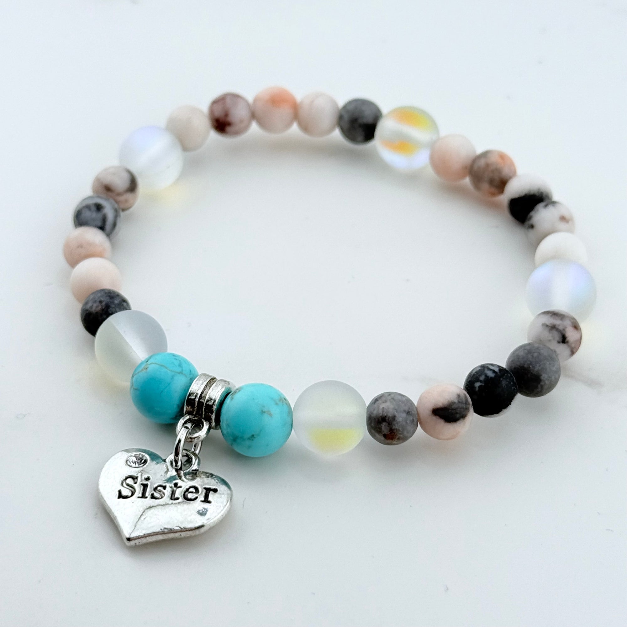 Beaded bracelet with a 'Sister' charm on a white background