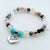 Beaded bracelet with a 'Sister' charm on a white background