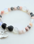Bracelet with multicolored beads and a 'Sister' charm on a light background