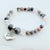 Beaded bracelet with a 'Sister' charm on a white background