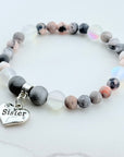 Beaded bracelet with a 'Sister' charm on a white background