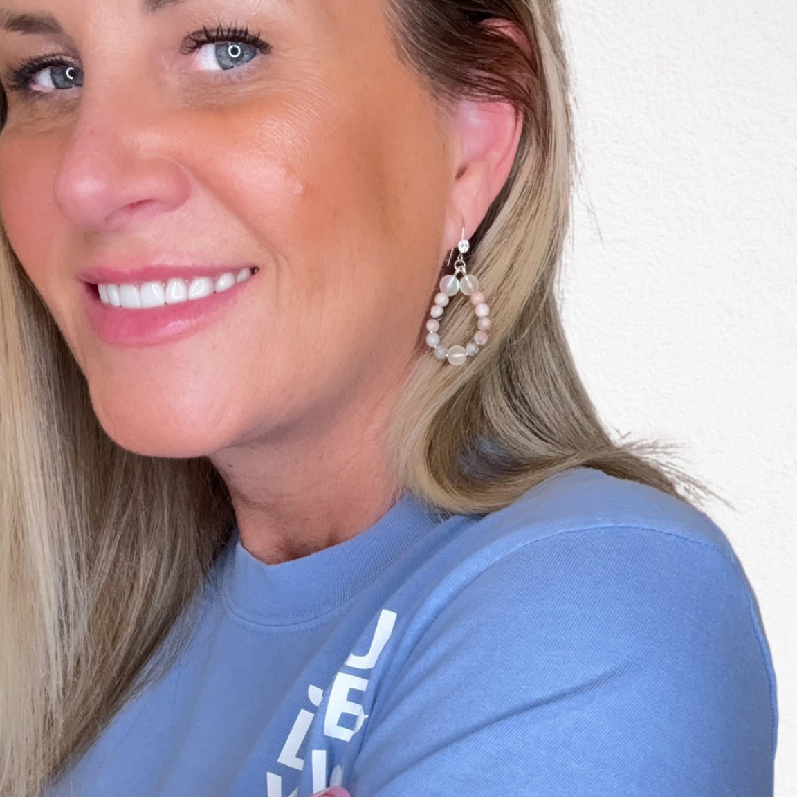 Woman wearing a blue t-shirt with a logo on a white background