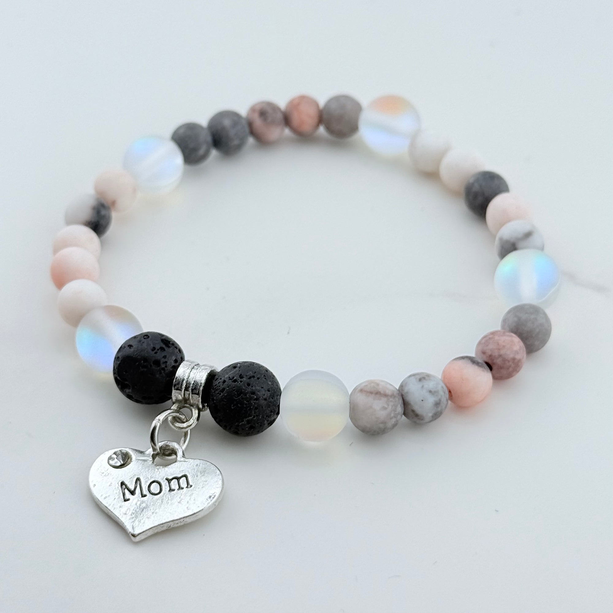 Beaded bracelet with 'Mom' charm on a light background