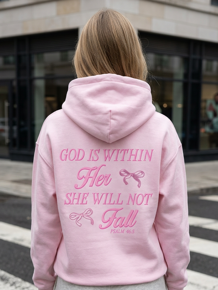 Person wearing a pink hoodie with text on the back, standing on a street.