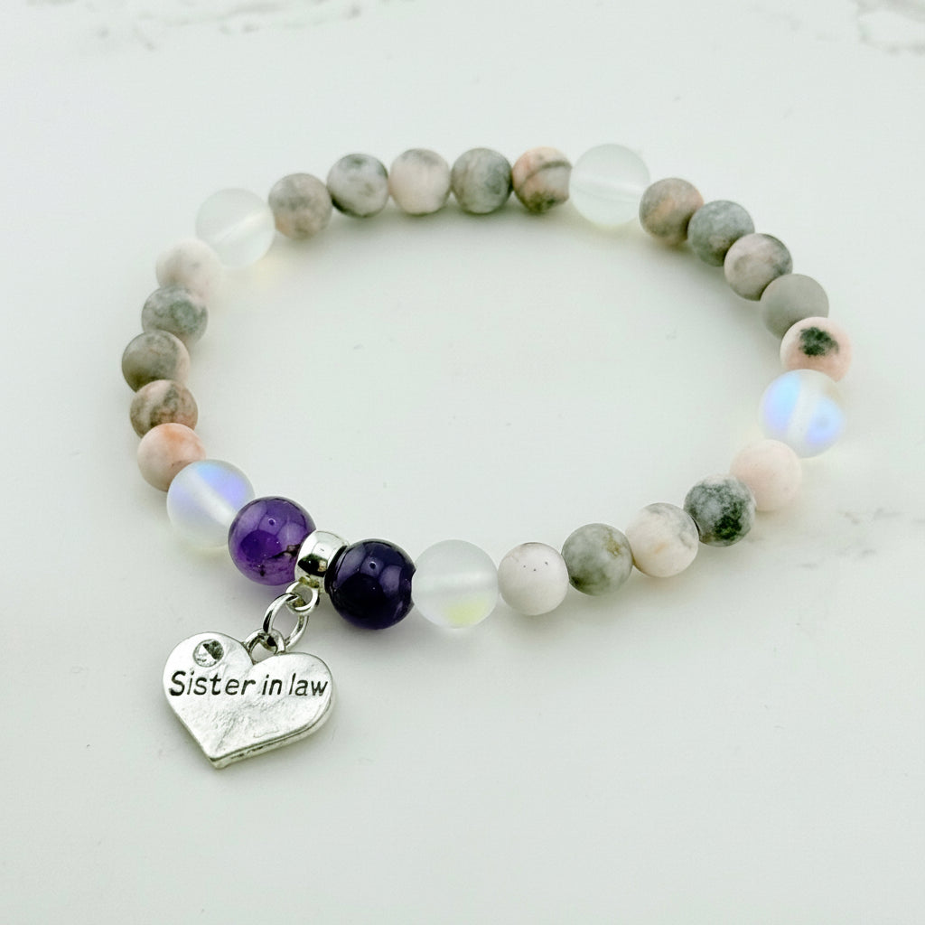Beaded bracelet with a heart-shaped 'Sister in law' charm on a light background