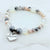 Beaded bracelet with a heart-shaped 'Sister in Law' charm on a white marble background