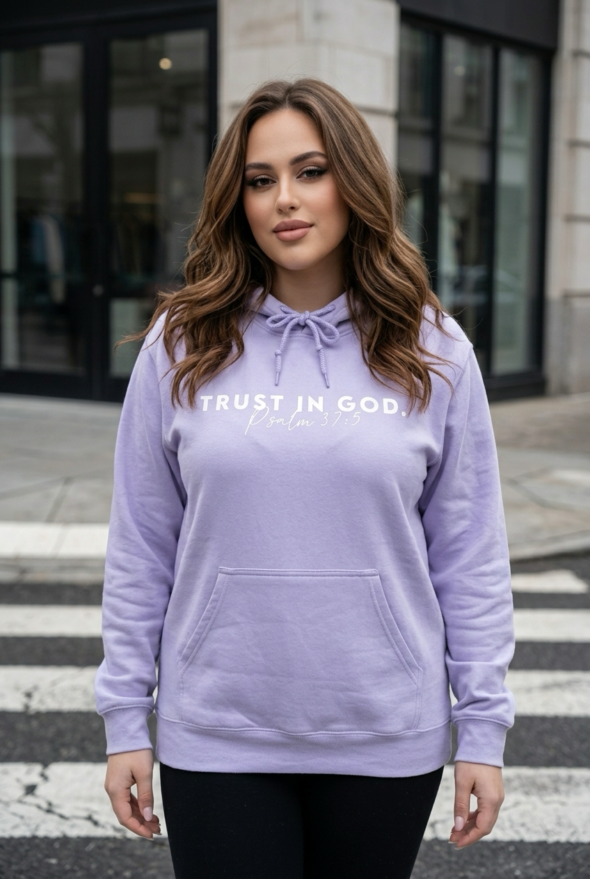 Woman wearing a lavender hoodie with text, standing on a crosswalk.